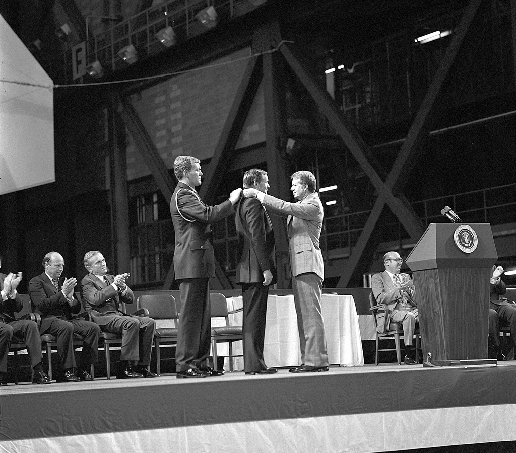 Astronaut Neil Armstrong received the first Congressional Space Medal of Honor from President Jimmy Carter, assisted by Captain Robert Peterson.