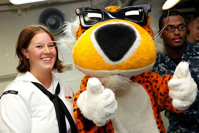 two navy sailors pose with Chester the Cheetah