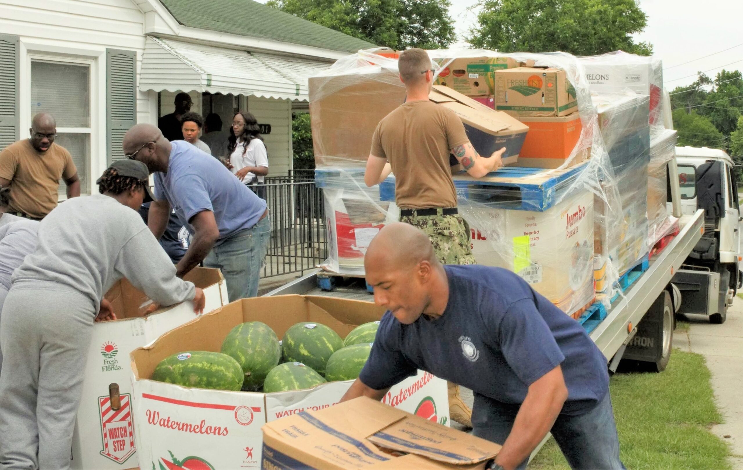 Fort Gordon Sailors unload 14 pallets containing approximately 3,500 pounds of food that were donated form the Faith Food Factory.