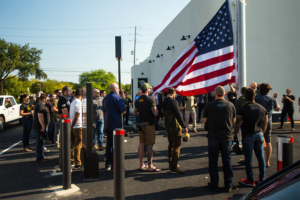 A group of people standing around an American flag.