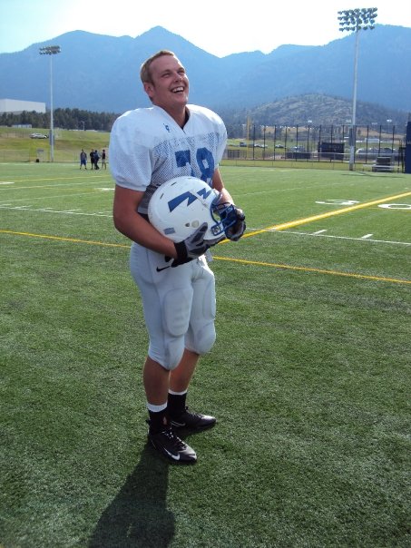 evan kaufman stands on a football field in his football uniform