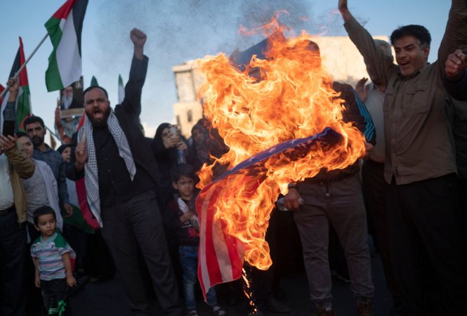 Protestors in Iran burn an American flag.