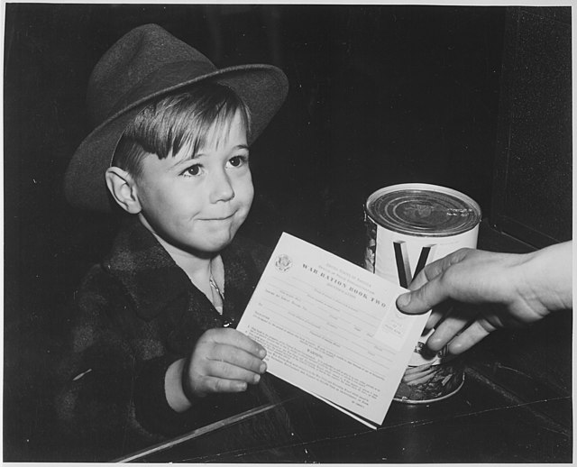 A young boy trades a war ration book for a can of V8 during WWII