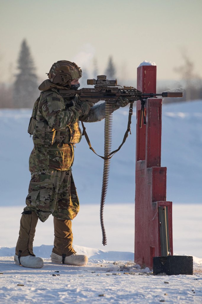 soldier fires a weapon in the snow