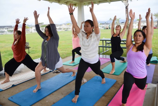 Spouses practice yoga outdoors