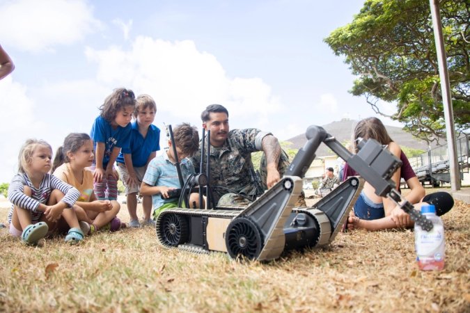 U.S. Marine Corps Sgt. Chad Cruz, a native of Talofofo, Guam, and an explosive ordnance disposal (EOD) technician with Marine Corps Base Hawaii EOD, teaches Military Homeschoolers of Hawaii students how to operate a 310 Small Unmanned Ground Vehicle during a capabilities and educational demonstration at MCBH, Sept. 21, 2023. Participants learned about military occupations, specifically those related to Science, Technology, Electronics, and Math, from MCBH explosive ordnance disposal technicians and Marathon Targets, a military technology company. (U.S. Marine Corps photo by Sgt. Julian Elliott-Drouin)