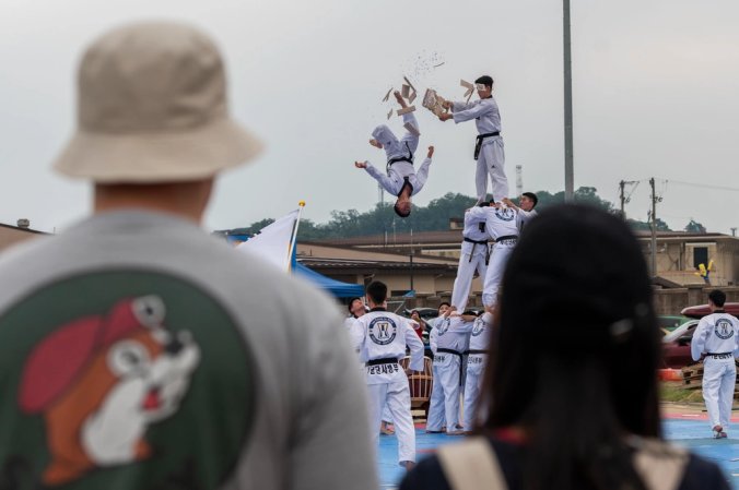 A family watches a taekwondo demo during Liberty Fest at Osan Air Base, Republic of Korea, July 4, 2024. The 51st Force Support Squadron hosted Liberty Fest to celebrate Independence Day for families stationed in the ROK. (U.S. Air Force photo by Staff Sgt. Ashley N. Mikaio)