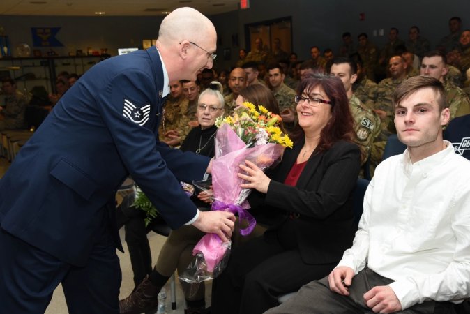 Tech. Sgt. Raymond P. Lucca Jr. assigned to the 105th Mission Support Group gives his wife Ellen Lucca flowers to show his appreciation for what as she has done to support him at Stewart Air National Guard Base, New York, March 4, 2018. Lucca had a retirement ceremony to celebrate his years in service.(U.S. Air Force photo by Airman 1st Class Mary Schwarzler)