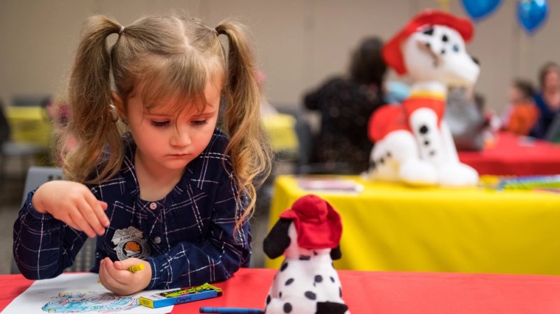 Juliana Bruner, daughter of Airman 1st Class Joshua Bruner, colors on a coloring page during the Exceptional Family Member Program’s Dinner with Sparky at Barksdale Air Force Base, Louisiana, Oct. 11, 2019. The night was dedicated to giving children in EFMP a chance to meet with first responders. (U.S. Air Force photo by Airman 1st Class Lillian Miller)