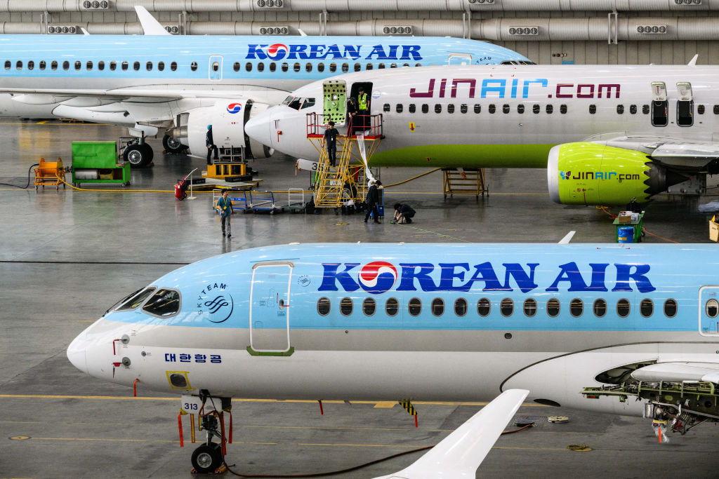 Employees are seen working at the Korean Air maintenance hangar with (top to bottom) Korean Air Airbus A220-200, Jin Air Boeing 737-8 and Korean Air Airbus A220-200 passenger aircraft during a media tour of the Korean Air headquarters in Seoul on June 27, 2024. (Photo by ANTHONY WALLACE / AFP) (Photo by ANTHONY WALLACE/AFP via Getty Images)