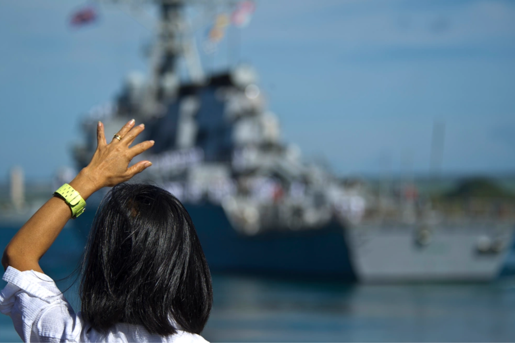 A U.S. Navy spouse waves goodbye to her husband aboard the guided-missile destroyer USS O'Kane (DDG77) as it departs Joint Base Pearl Harbor-Hickam, Hawaii on March 23, 2012, for a deployment to the Western Pacific. USS O'Kane, is deploying under the Middle Pacific Surface Combatant (MPSC) deployment concept in which Pearl Harbor-based ships deploy in support of operations primarily in the Western Pacific under Commander, U.S. 7th Fleet.