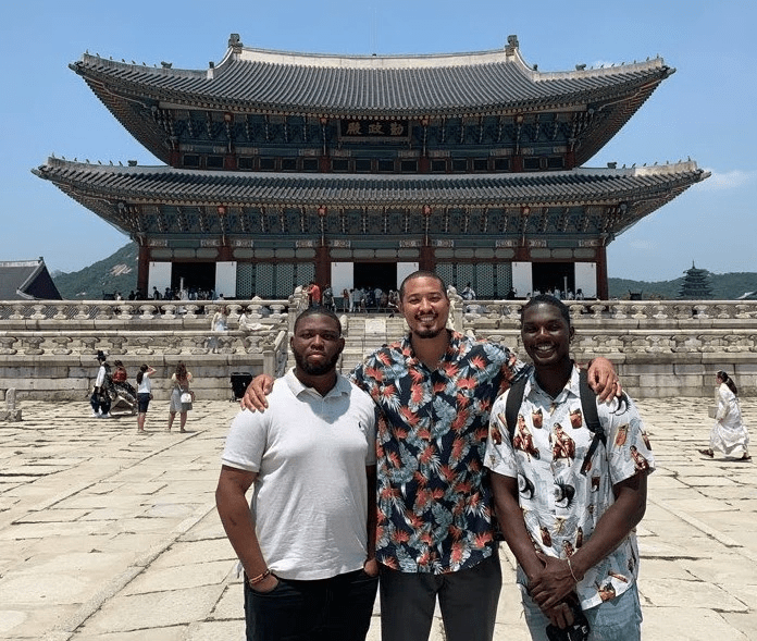 Three people pose in front of Gyeonbbokgung Palace