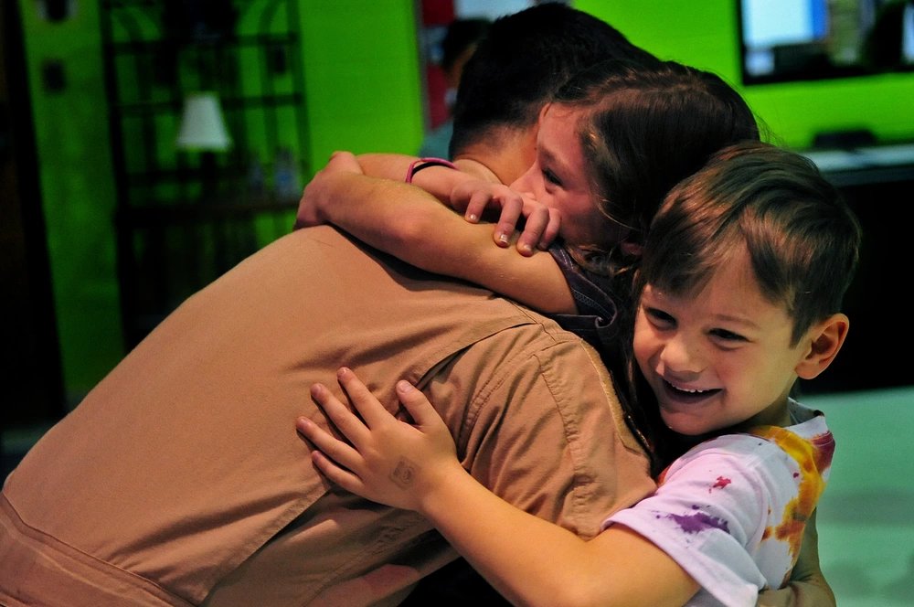 Capt. Christopher Benson, 916th Air Refueling Wing KC-135R Stratotanker pilot, hugs his kids, Feb. 18, 2014, at Seymour Johnson Air Force Base, N.C. Benson surprised his kids by returning home early from about a three month deployment to Southwest Asia. (U.S. Air Force photo by Airman 1st Class Shawna Keyes)