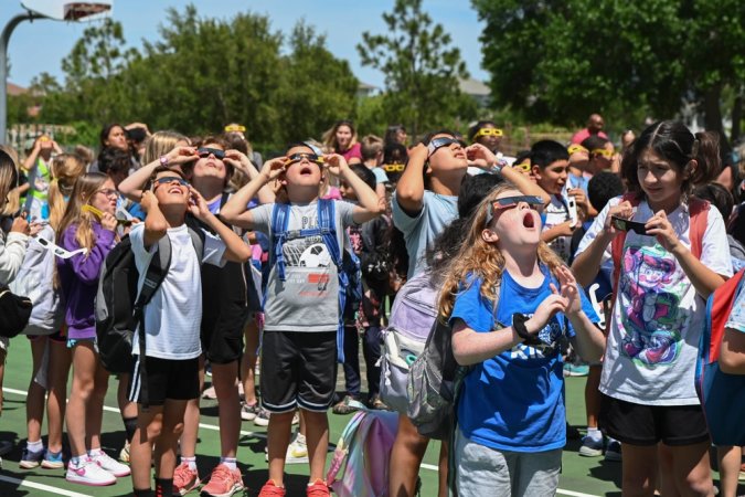 Students watch the solar eclipse at Tinker K-8 School, April 8, 2024, at MacDill Air Force Base, Florida. This was the first time a total solar eclipse was visible in the U.S. since 1979. The MacDill community gathered to celebrate the eclipse with educational videos and moon-themed snacks. (U.S. Air Force photo by Senior Airman Jessica Do)