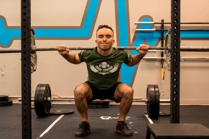 Capt. Zachary Johnson performs weighted back squats for his circuit workout during the MacDonald Hero Workout event at Iron Empire gym in Dover, N.H., Nov. 10, 2015. Iron Empire hosted a community workout in honor Lance Cpl. MacDonald, a Marine who lost his life in Iraq in 2003, or whomever the participants individually wanted to honor. Johnson is the executive officer of Recruiting Station Portsmouth, N.H.