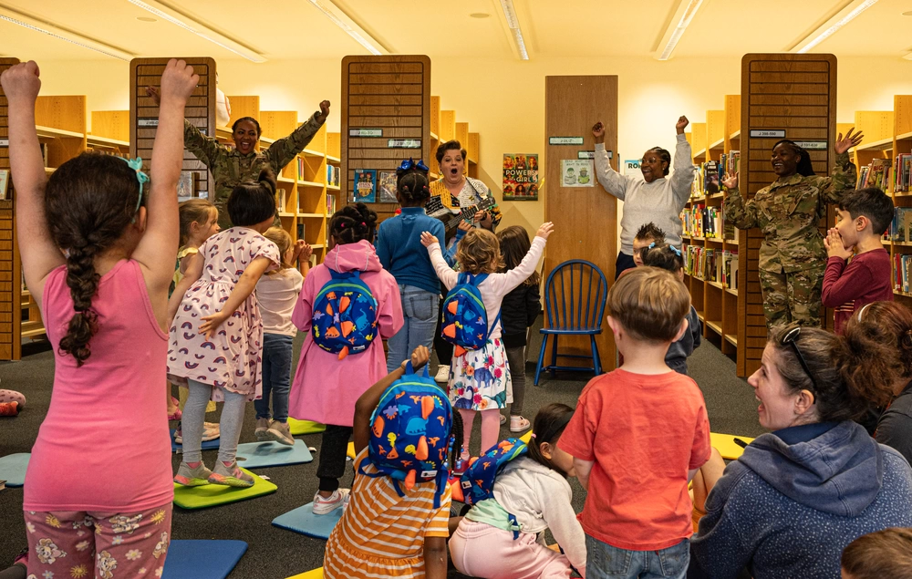 Darcie Calis, center, Ramstein Library volunteer, sings a song with children during a Juneteenth book reading at Ramstein Air Base, Germany, June 20, 2024. Calis helped other volunteers read books about Juneteenth to children and teach them about the importance of freedom in the U.S. (U.S. Air Force photo by Senior Airman Thomas Karol)