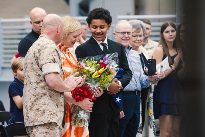 Gina Pickelsmier, wife of U.S. Marine Corps Lt. Col. Eric Pickelsmier, former operations officer for Headquarters and Support Battalion receives flowers during a retirement ceremony at the National Museum of the Marine Corps, Triangle, Virginia, July 20, 2024. Pickelsmier was awarded the Meritorious Service Medal, gold star in lieu of the second award, for his 22 years of service upon his retirement. (U.S. Marine Corps photo by Cpl. Darien Wright)