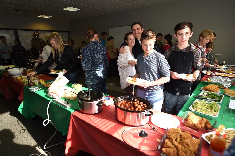 Sailors and their family members get to enjoy the annual potluck held at Navy Operational Support Center Fort Carson. The annual potluck is where the service member and their families can enjoy lunch together during the holiday season. (U.S. Navy photo by Mass Communication Specialist 1st Class Gilbert Bolibol/Released)