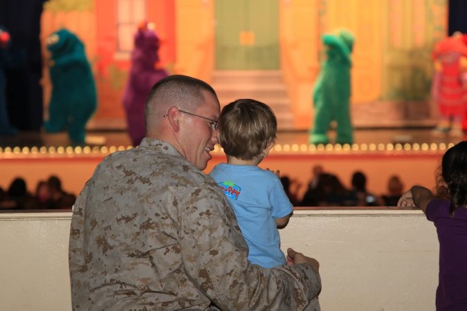 Staff Sgt. Anthony Richmond and his 1-year-old son Coleton applaud at the end of a song-and-dance routine. USMC photo.