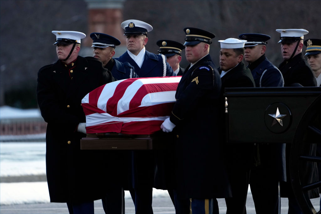 WASHINGTON, DC - JANUARY 7: The flag-draped casket of former President Jimmy Carter is carried by a joint services body bearer team on the East Front of U.S. Capitol on January 7, 2025 in Washington, DC. Carter's body will lie in state in the Capitol Rotunda until a funeral service at the National Cathedral in Washington on January 9. Carter, the 39th President of the United States, died at the age of 100 on December 29, 2024 at his home in Plains, Georgia. (Photo by Susan Walsh - Pool/Getty Images)