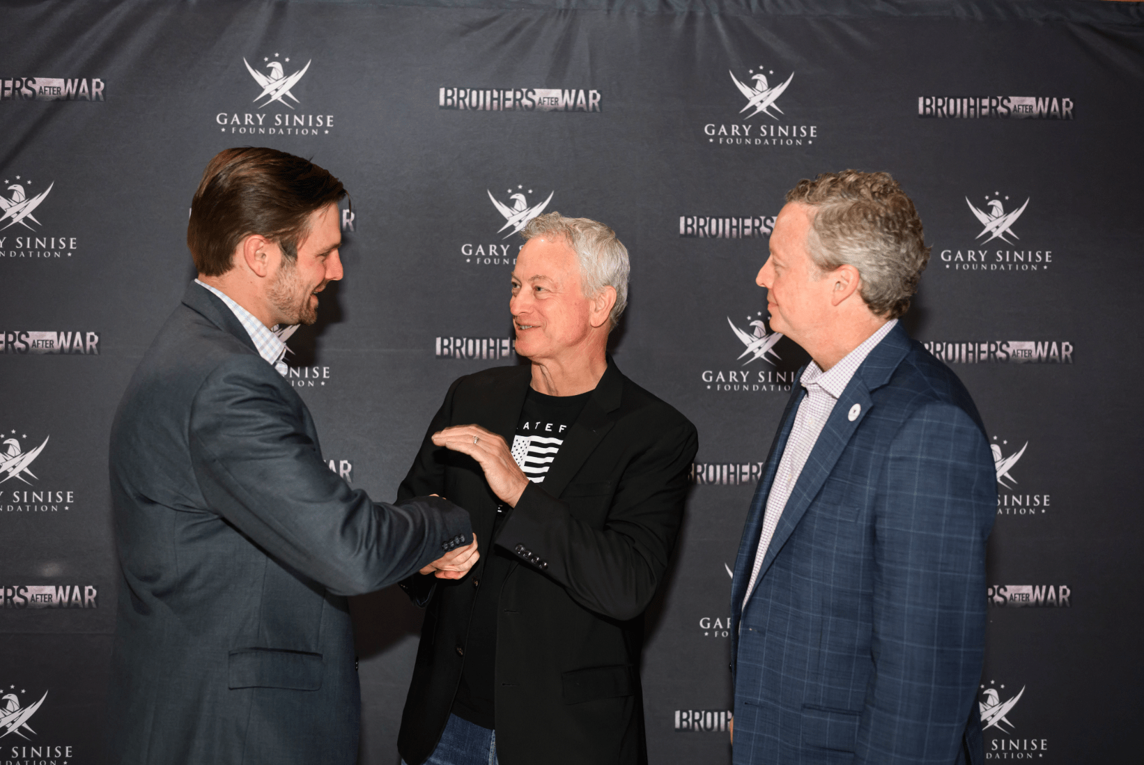 Joe Rademacher (left) shakes hands with Gary Sinise at the Nashville red carpet premiere of the film Brothers After War. Also pictured, director Jake Rademacher. Photo courtesy Gary Sinise Foundation.