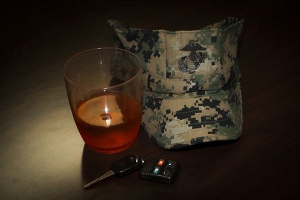 A beer next to a camo hat in the barracks