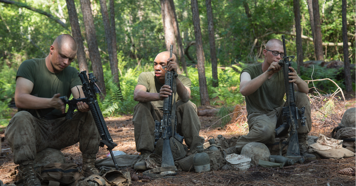 Marines clean their M164As while sitting on rocks