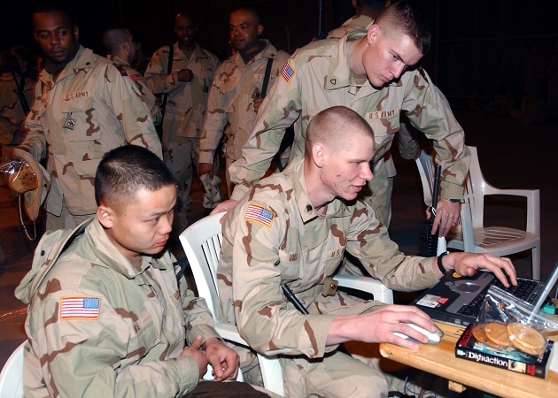 Army soldiers sitting in lawn chairs on deployment