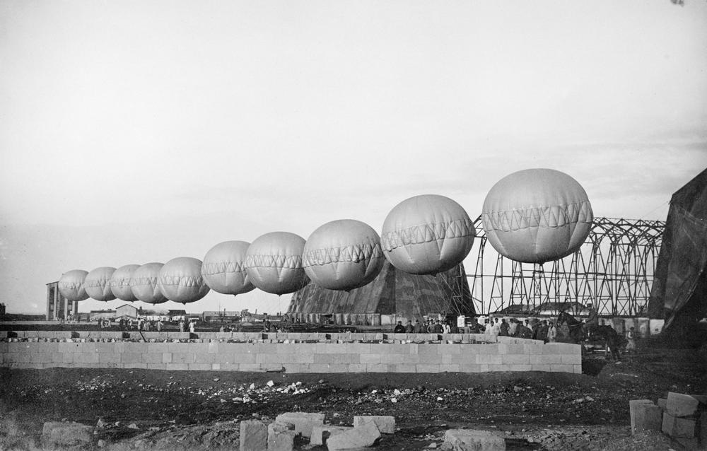 A row of spherical barrage balloons used for suspending aerial nets